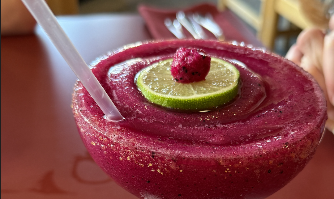 A frozen dragonfruit margarita at Yen Ching, garnished with a lime wheel and a dragonfruit chunk
